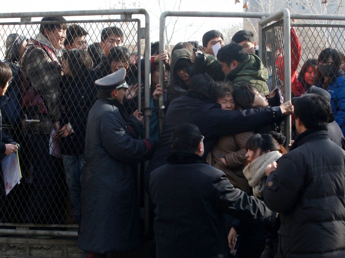 But as the exam approaches, things get even more intense. Here, police try to contain people as they line up to register for the exam.