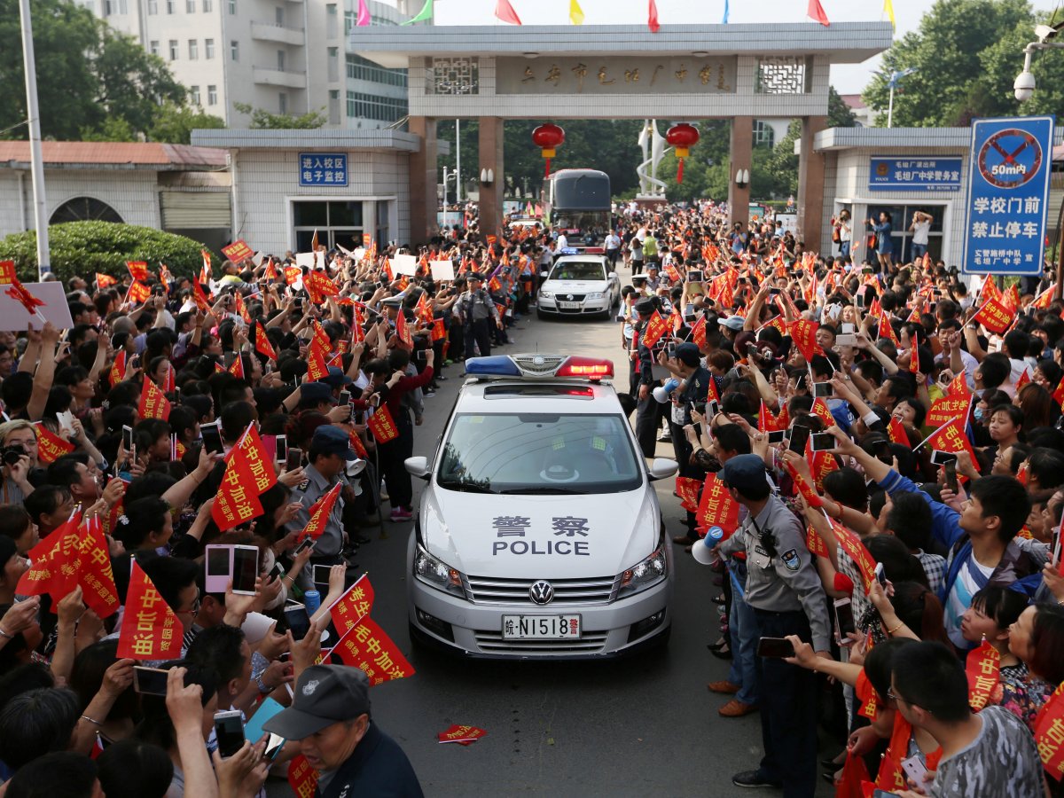 On the day of the exam, police vehicles clear a path for students leaving school to attend the gaokao.