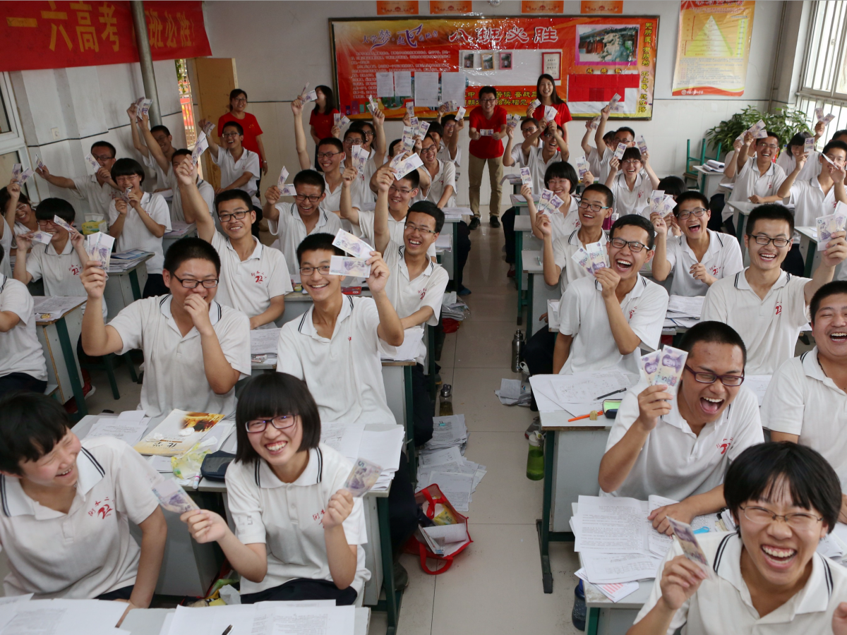 Students in a Hebei Province school hold up two 5 yuan banknotes that their school gives for good luck before the exam.