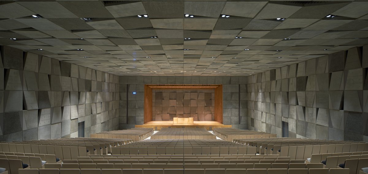 The motif even penetrates the auditorium, which has paneled gray walls and black and white seats.